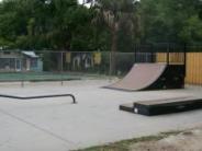 Concrete skatepark with bars and ramps dotted around the park