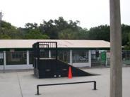 A large skate ramp with a orange safety cone sitting beside the ramp